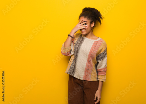 Young black african american girl with blue eyes embarrassed and laughing at the same time photo