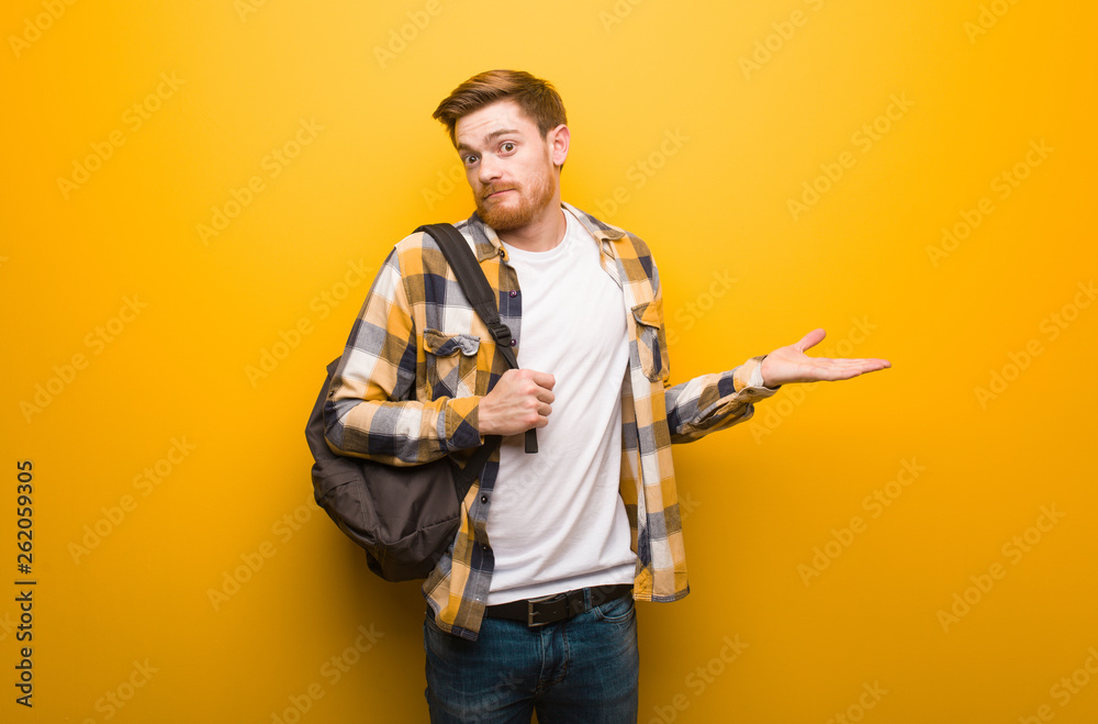 Young redhead student man confused and doubtful Young redhead student man confused and doubtful