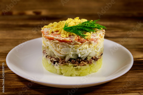 Traditional russian salad Mimosa on wooden table