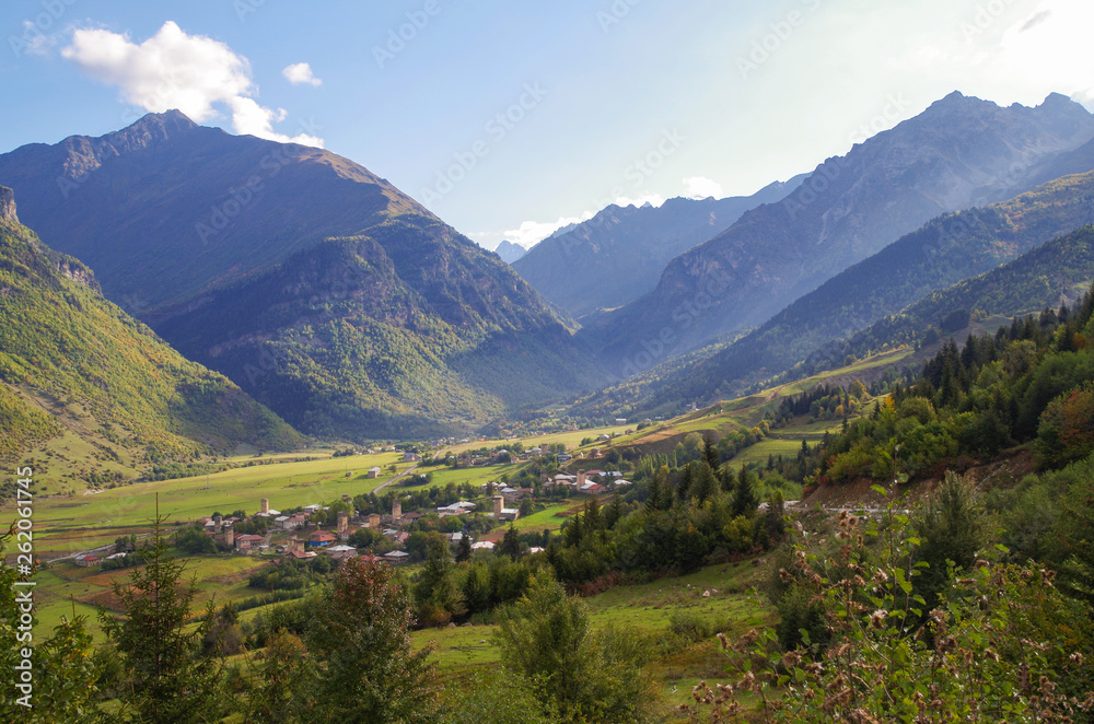 Scenic autumn landscape in the mountains of the Caucasus. View of the valley and village with ancient Svan towers. Nature and travel. Georgia, Svaneti region
