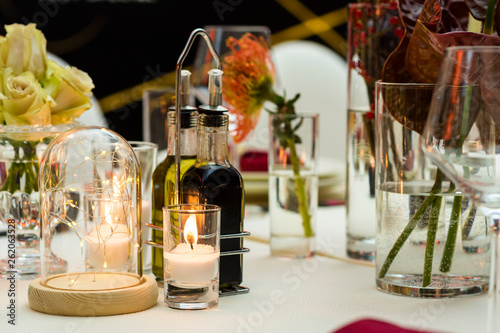 electric and natural candles and glass at the table setting