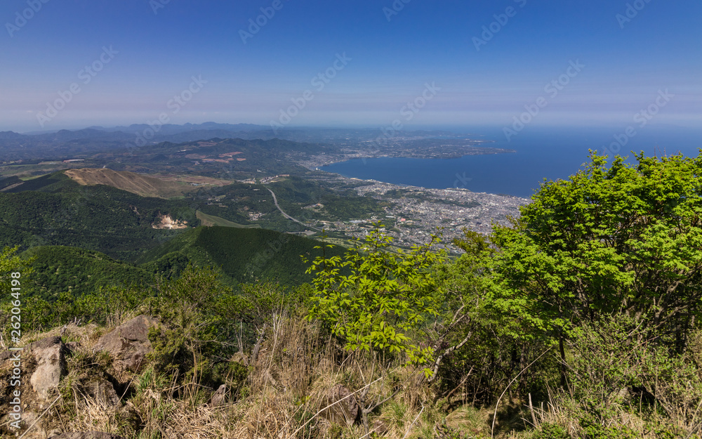 View on Beppu City and Bay between Mountains of Kyushu and green Landscape in the foreground from Mount Tsurumi. Beppu, Oita Prefecture, Japan, Asia.
