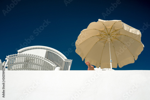 Sunshade, resting person crossed feet photo