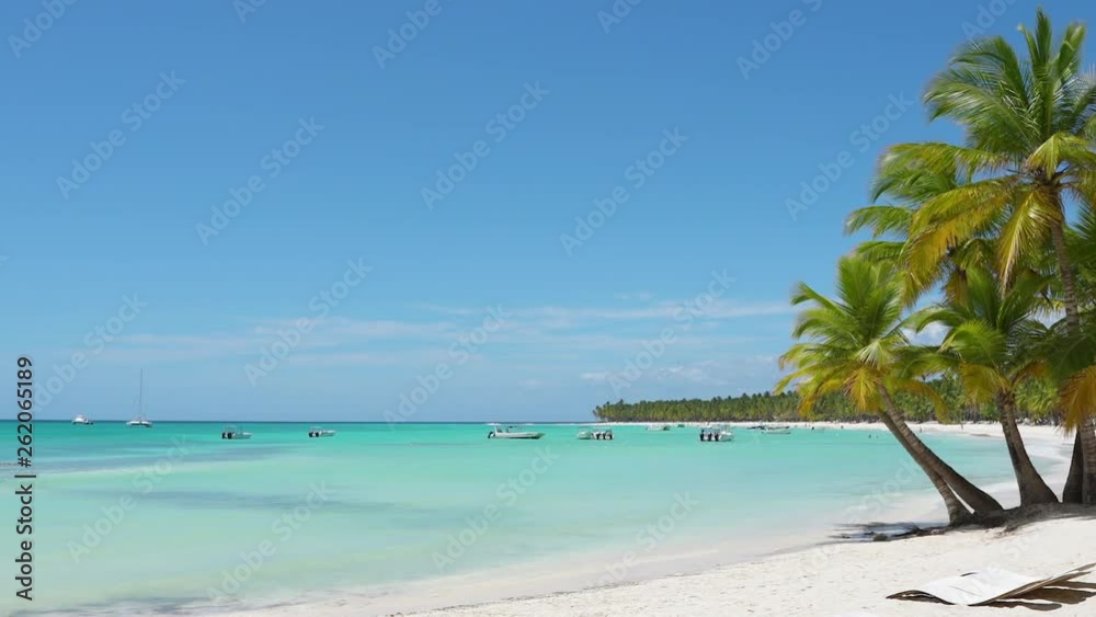Bounty Beach summer idyllic resort Palm island beach Dominican Republic. Turquoise ocean water and bright blue sky on a sunny day is a beautiful seascape. Bounty Beach summer idyllic resort Palm island beach Dominican Republic. Turquoise ocean water and bright blue sky on a sunny day is a beautiful seascape.