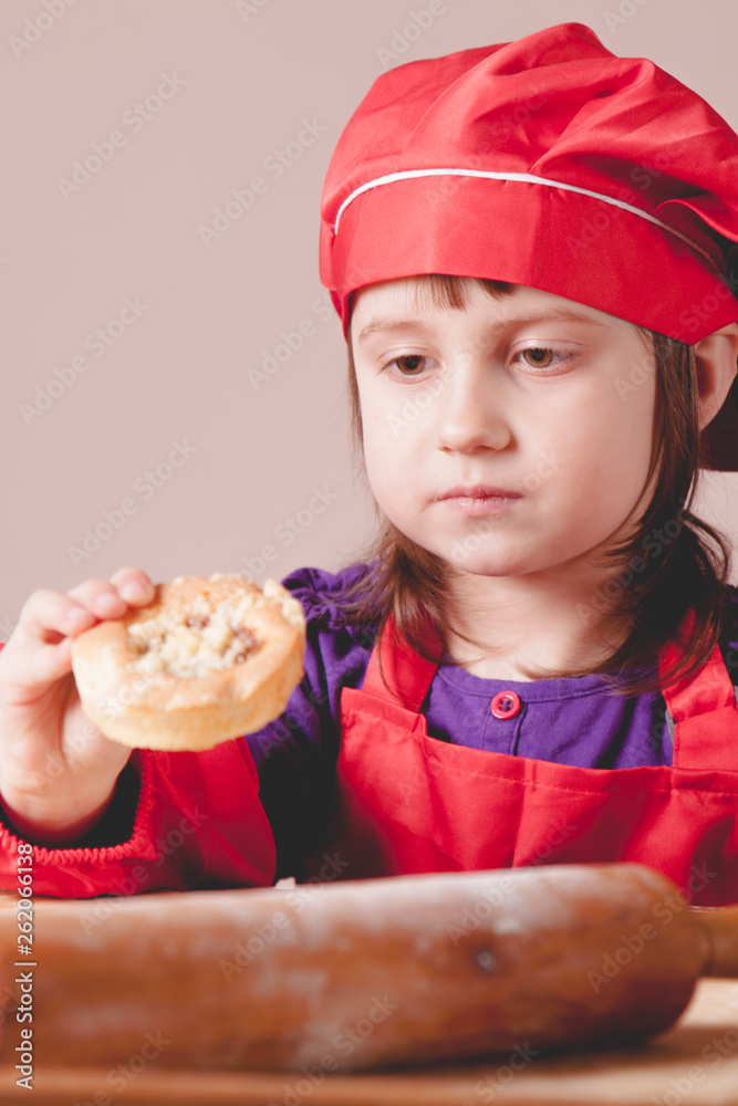 Cute little child girl chef making cooking homemade cakes. Food and сooking process concept. Cute little child girl chef making cooking homemade cakes. Food and сooking process concept.