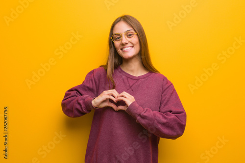 Young casual woman doing a heart shape with hands