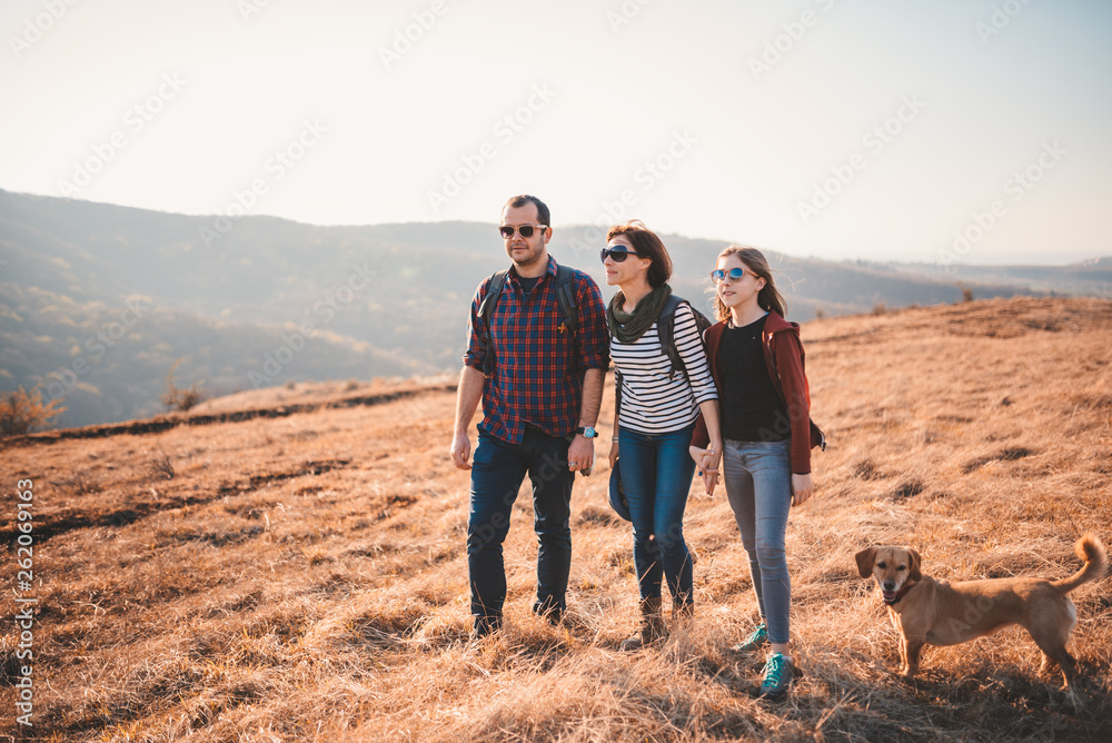 Family with dog hiking on a mountain