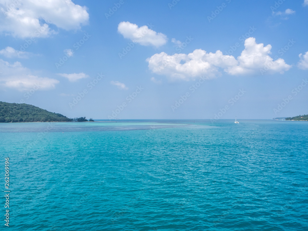 White yacht floating in the turquoise sea to the island with clouds. Koh Phangan. Thailand.	