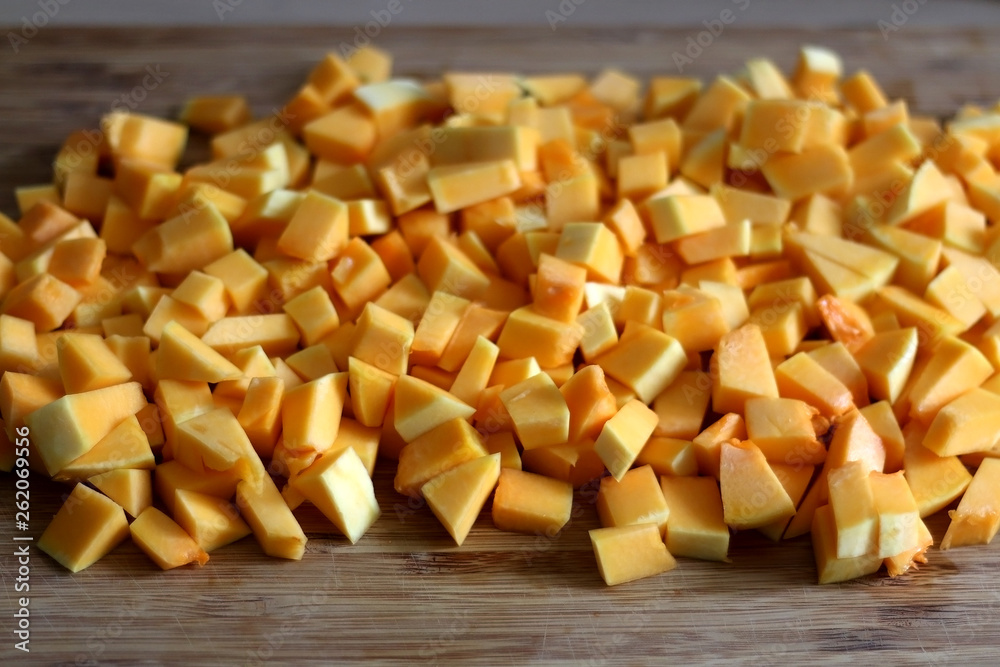 Chopped butternut squash on wooden cutting board. Selective focus. Chopped butternut squash on wooden cutting board. Selective focus.