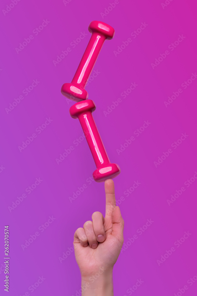 Woman hand taking easy pink dumbbells Woman hand taking easy pink dumbbells