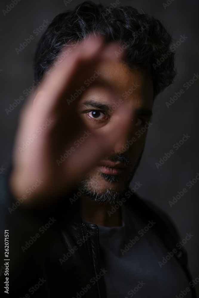 Portrait of an Indian man, looking through fingers Portrait of an Indian man, looking through fingers