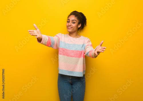 Bild auf Leinwand Young black african american girl with blue eyes inviting to come