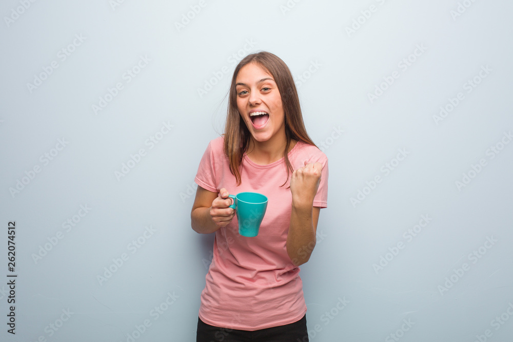 Young pretty caucasian woman surprised and shocked. She is holding a mug. Young pretty caucasian woman surprised and shocked. She is holding a mug.