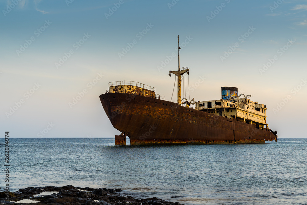 Spain, Lanzarote, Stranded rusty ship wreck temple hall at arrecife beach in magic light