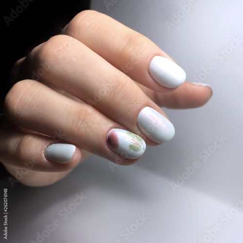 Female white manicure on nails against a dark background