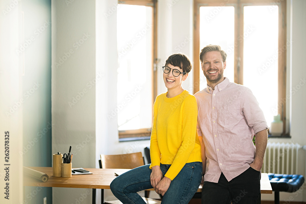 Portrait of happy couple at table in stylish apartment