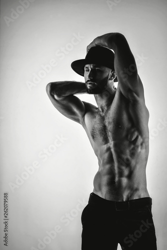 Black and white photo of a handsome sportsman brutal man in a black hat