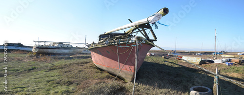 Retired yacht resting on shore at low tide