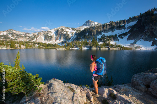 A female backpacker stands near Mirror Lake in the Eagle Cap Wilderness of the Wallowa Mountains in northeast Oregon at sunset. photo