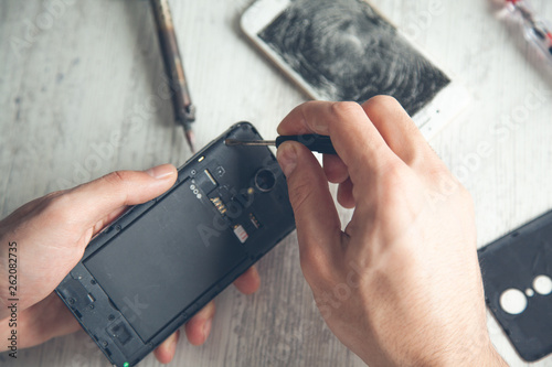 worker hand broken phone on wooden desk