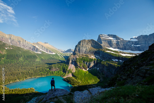 A woman stops to take in the view while hiking down from the Grinell Glacier in the Many Glacier area of Glacier National Park. Grinell Lake is in the background. photo