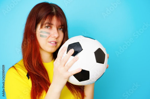 Woman is socccer fan in yellow t-shirt with soccer ball