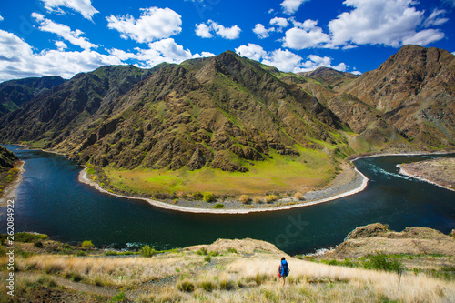 A female backpacker on the scenic Snake River National Recreation Trail (#102) in Hells Canyon along the Oregon-Idaho border. The canyon is the deepest river gorge in North America with more than a mile of vertical elevation between the river floor and nearby peaks in the Seven Devil Mountains.