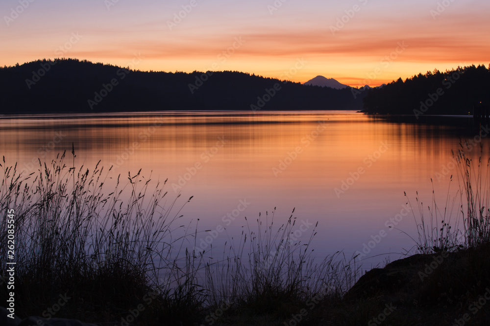 Sunrise over Harney Channel as seen from Blind Island, a small 3 acre state park in the San Juan Islands of Washington  that offers camping opportunities to human and wind-powered boats. Mount Baker is in the distance.