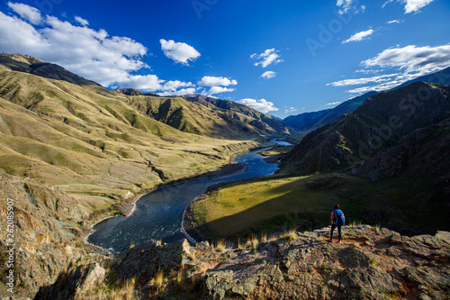 A female backpacker at the 400-foot Suicide Point along the scenic Snake River National Recreation Trail (#102) in Hells Canyon along the Oregon-Idaho border. The canyon is the deepest river gorge in North America with more than a mile of vertical elevation between the river floor and nearby peaks in the Seven Devil Mountains. photo