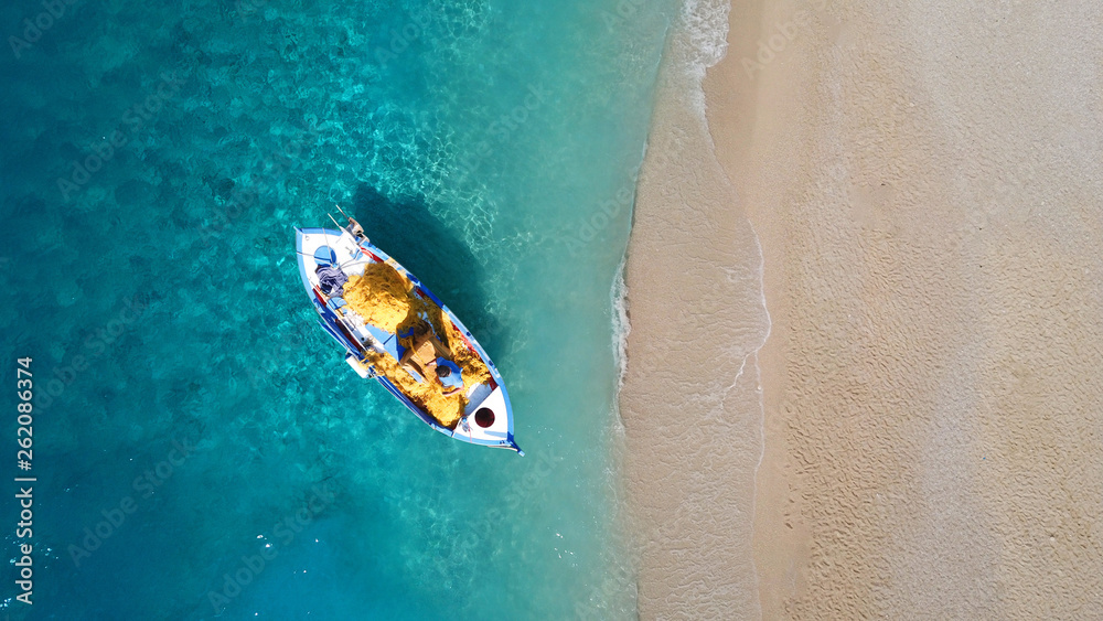 Fototapeta premium Widok z góry z drona z lotu ptaka Zdjęcie czerwonej drewnianej tradycyjnej łodzi rybackiej na turkusowym brzegu morza na wyspie Zakynthos, Jońskie, Grecja