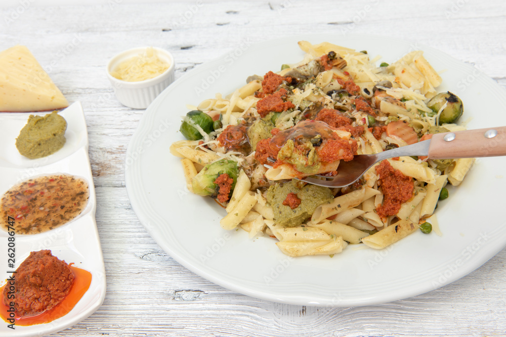 Pasta de macarrones con salsa roja, amarilla y verde.