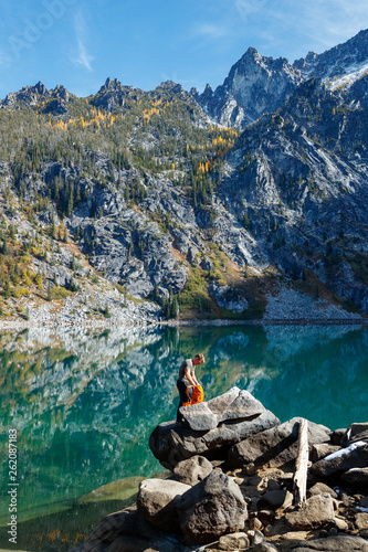 A man with a pack hikes amidst fall colors near Colchuck Lake in the Cascade Range of Washington State. photo