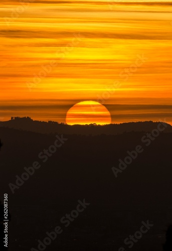 Panorama al tramonto con cielo pennellato e silhouette del paesaggio