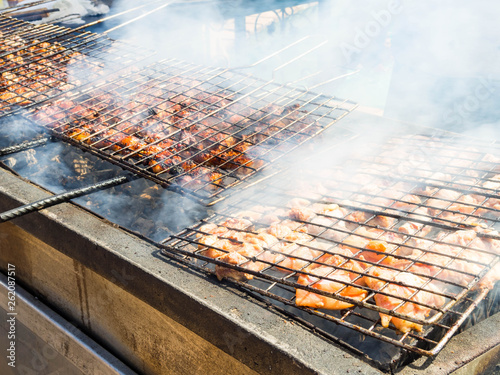 Grilled meat barbecue on charcoal stove with full of smoke. Or fire charcoal in stove for cooking food and barbecue.(Soft focus with firm grain)