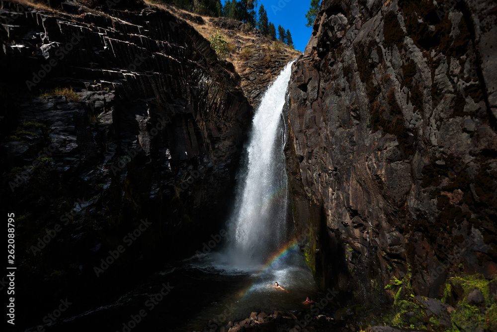 Two women escape the summer heat, swimming below the Middle Falls at Elk Creek Falls in northern Idaho in the Nez Perce - CLearwater National Forest. The 2 mile loop trail (the remnants of an old wagon trail), takes you to Upper, Middle, and Lower Elk Creek Falls. Two women escape the summer heat, swimming below the Middle Falls at Elk Creek Falls in northern Idaho in the Nez Perce - CLearwater National Forest. The 2 mile loop trail (the remnants of an old wagon trail), takes you to Upper, Middle, and Lower Elk Creek Falls.