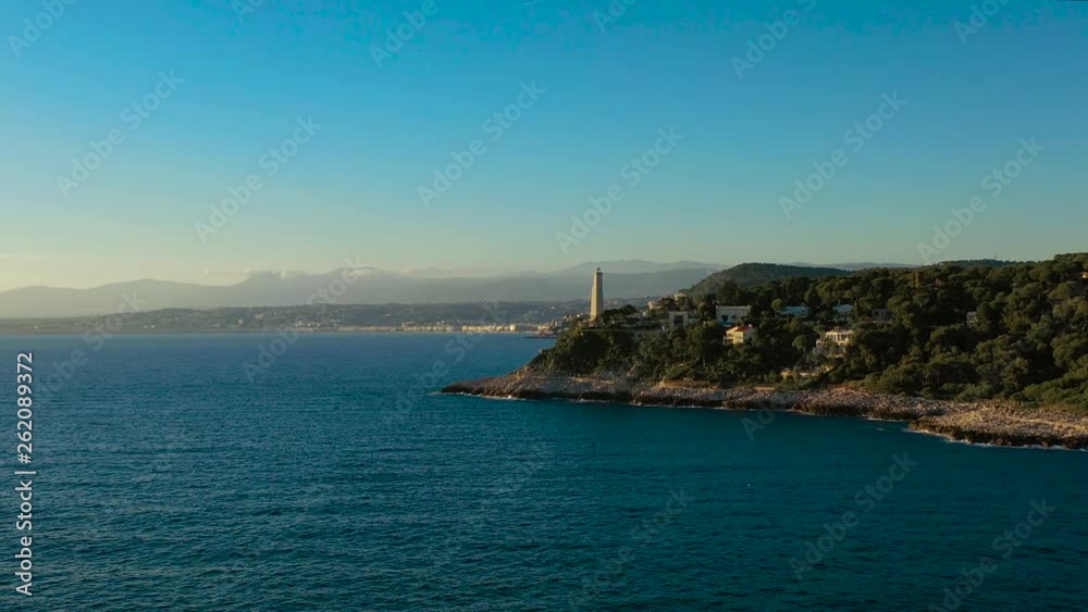 Fly over a promenade on Azure coast with strolling, walking and running people ending with fly into a Lighthouse Fly over a promenade on Azure coast with strolling, walking and running people ending with fly into a Lighthouse