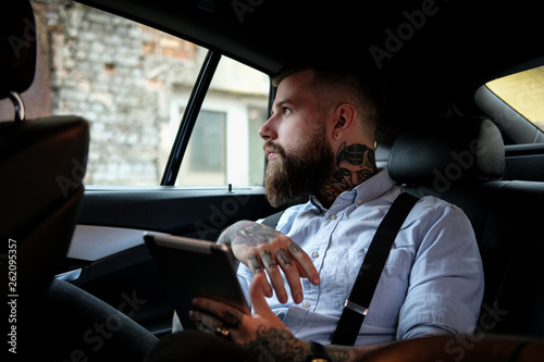 Portrait of bearded man with tattoes in the car © Fxquadro