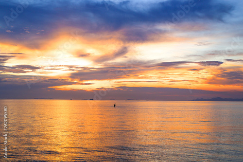sunset orange over the sea and a man far out to sea