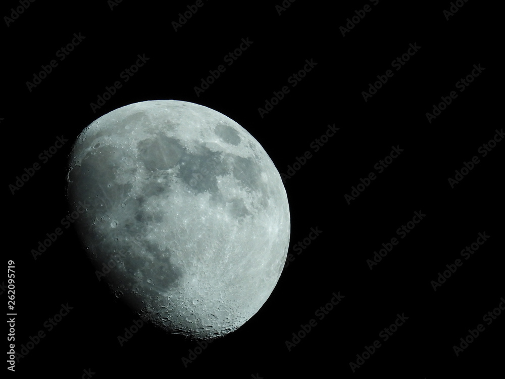 a close-up of a three-quarter moon in the night sky a close-up of a three-quarter moon in the night sky