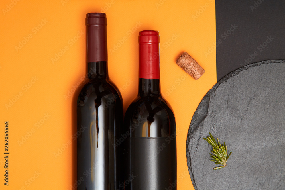 Layout of black slate board with bottle of wine on colorful geometry background