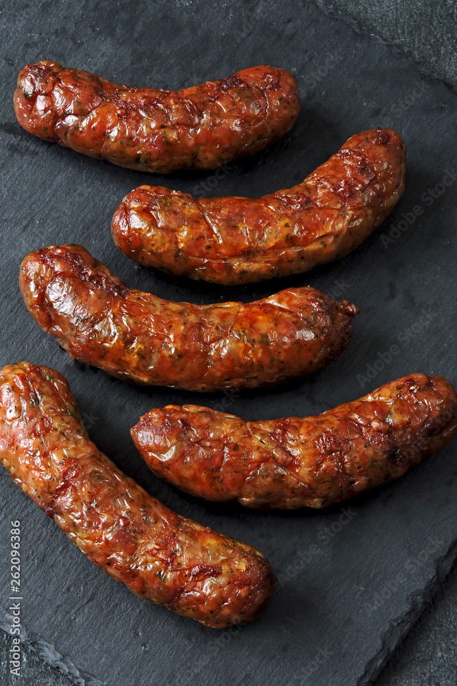 Grilled Bavarian sausages with spices on a stone board. Copy space. Grilled Bavarian sausages with spices on a stone board. Copy space.