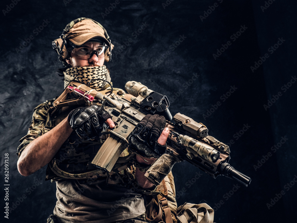 Fully equipped soldier in camouflage uniform holding an assault rifle ...