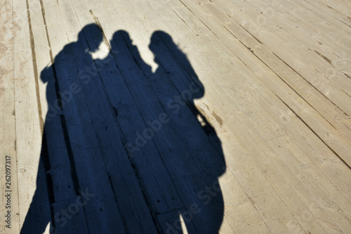 Shadows of a family making selfie on timber floor