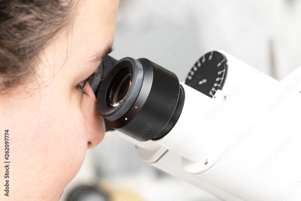 Biologist who is observing scientific samples under a microscope Biologist who is observing scientific samples under a microscope