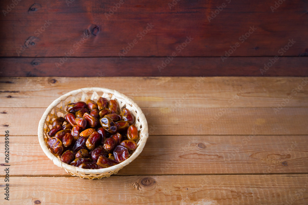 Dried dates on wooden background. Holy month of Ramadan, concept. Righteous Muslim lifestyle. Starvation. Dates in a wooden basket in the style of minimalism. Copy space Dried dates on wooden background. Holy month of Ramadan, concept. Righteous Muslim lifestyle. Starvation. Dates in a wooden basket in the style of minimalism. Copy space