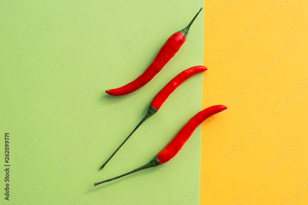 Red hot chillies on yellow and green background Red hot chillies on yellow and green background