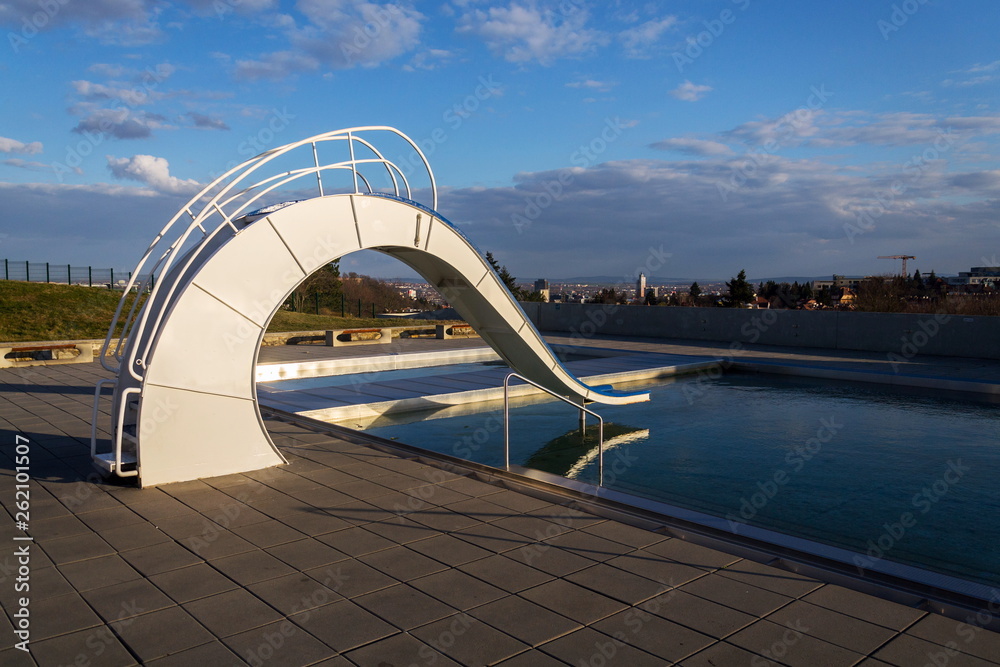 Naklejka premium White water slide with outdoors pool, beautiful sunset, clear blue sky background