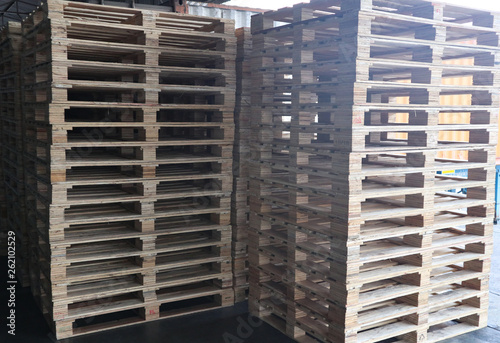 The forklift and wooden pallets heap in the cargo warehouse for transportation and logistics 