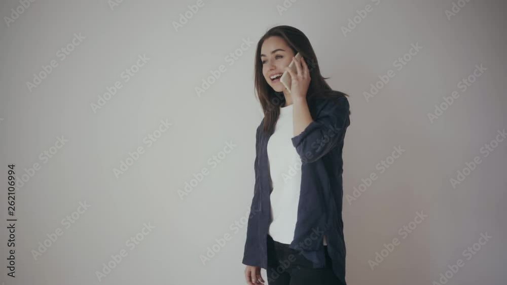 Young girl talking via mobile phone very surprised and happy, laughing, smiling and saying yes, wow and congratulating her friend for good news or that she got a new job, white isolated background Young girl talking via mobile phone very surprised and happy, laughing, smiling and saying yes, wow and congratulating her friend for good news or that she got a new job, white isolated background