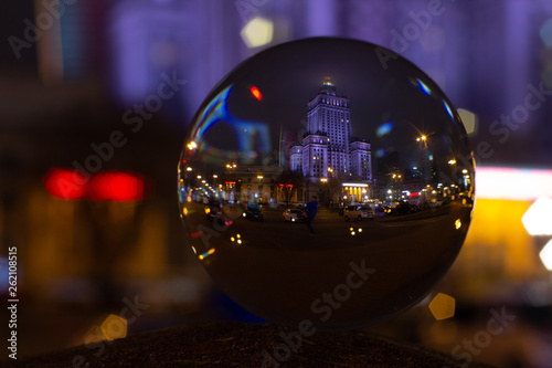 Lens Ball photo of Palace of Culture and Science Warsaw - reflection in crystal ball at night in rainy autumn time.